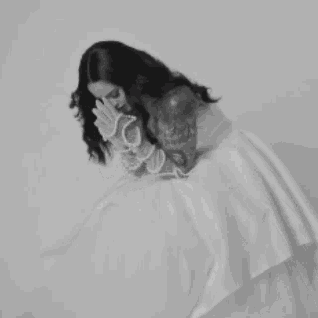 a woman in a wedding dress with tattoos on her arms