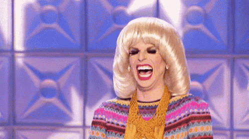 a woman in a wig is laughing with her mouth open .