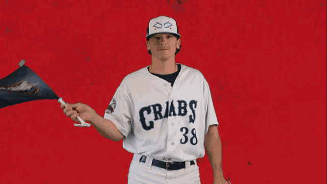 a man wearing a crabs jersey holds a small flag