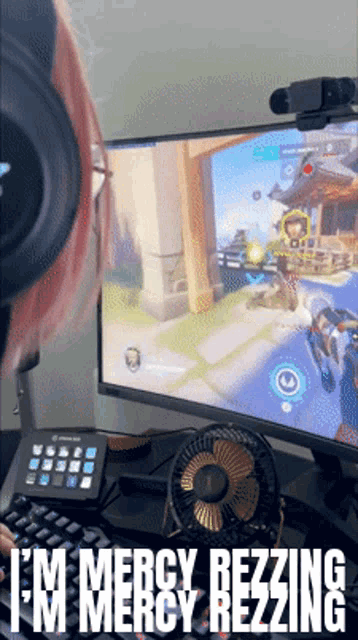 a woman playing a video game with the words " i 'm mercy rezzing " on the bottom