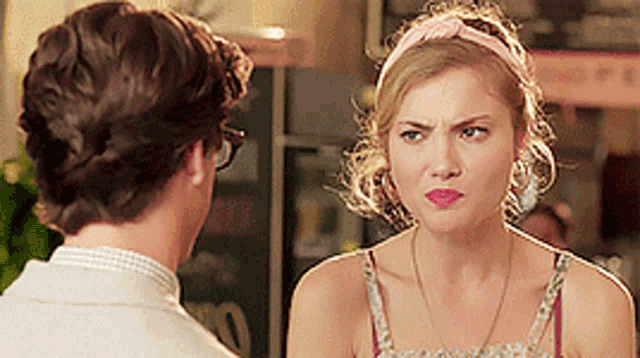 a man and a woman are looking at each other and the woman is wearing a headband