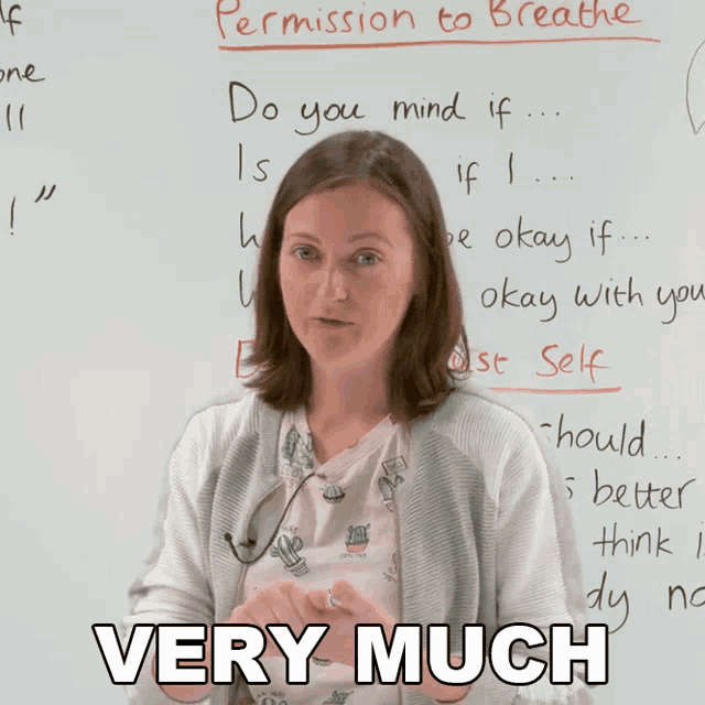 a woman stands in front of a white board that says permission to breathe on it