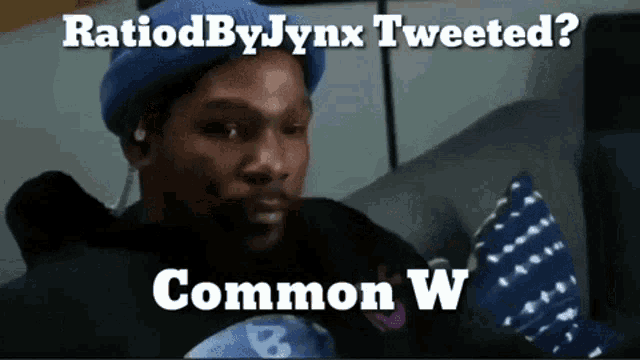 a man in a blue hat is sitting on a couch with the caption ratiodby jynx tweeted