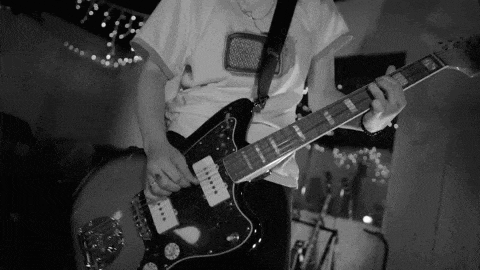 a black and white photo of a man playing an electric guitar