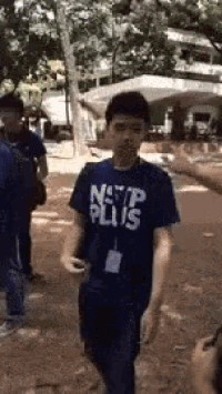 a man in a blue shirt is walking in a park .