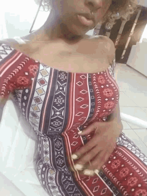 a woman in a red and white striped dress holds her belly