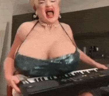 a woman with very large breasts is holding a keyboard .