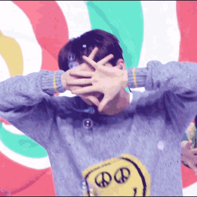 a man wearing a sweater with a smiley face on it