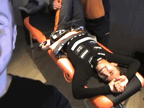 a man in a black shirt is laying on a table with a person in a black shirt that says ' supreme '