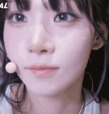 a close up of a girl 's face with a microphone in her ear .