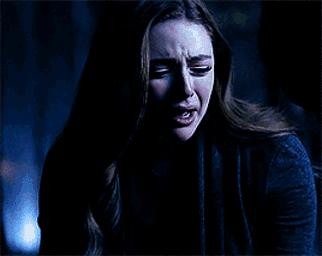 a woman is screaming with her mouth open in the dark .