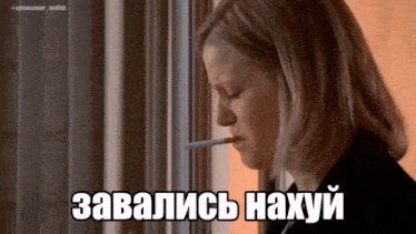 a woman smoking a cigarette in front of a window with a caption in russian that says " завались нахуй "