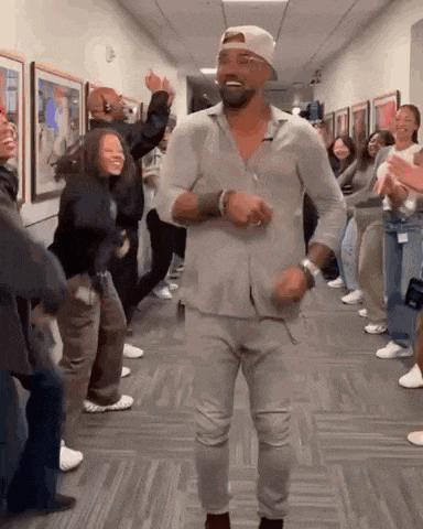 a man is dancing in a hallway surrounded by people .