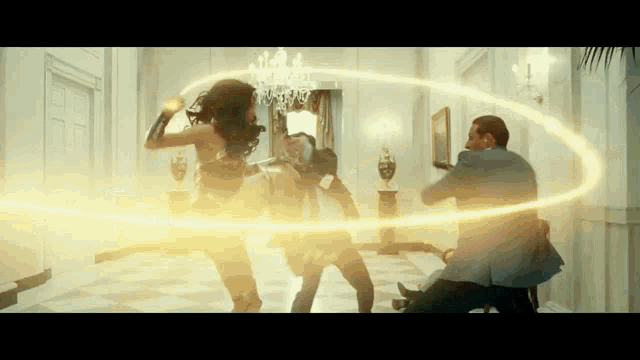 a woman in a superhero costume is fighting a man in a suit