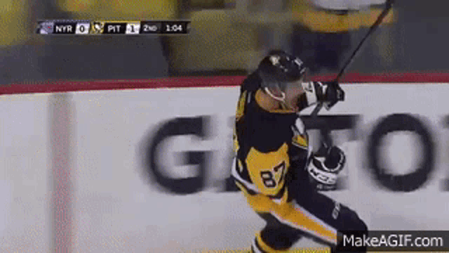 a hockey player with the number 87 on his jersey is holding a hockey stick