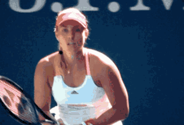 a woman is holding a tennis racquet in front of a sign that says ' u.s. open '