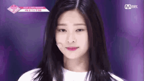a woman with long black hair is looking at the camera .
