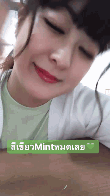 a woman in a green shirt is smiling with a green sticker that says mint on it