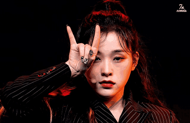 a close up of a woman making a devil horns sign with her fingers