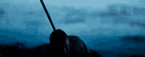 a man is holding a stick in his hand in front of a body of water .