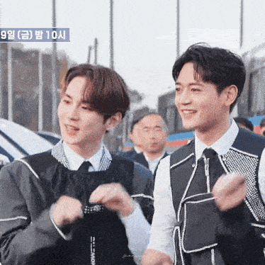 two young men are standing next to each other and one of them is wearing a vest that says ' nct dream '