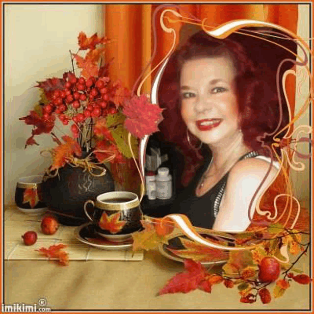 a woman is sitting at a table with a cup of coffee and a vase of berries .