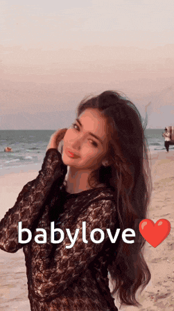 a woman standing on a beach with the word babylove written on the bottom