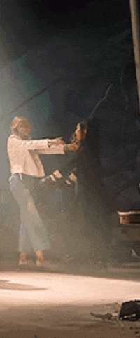 a man in a white jacket is holding a woman in his arms while standing on a stage .
