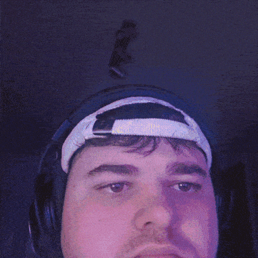 a man wearing headphones and a headband has a camera hanging from the ceiling above his head