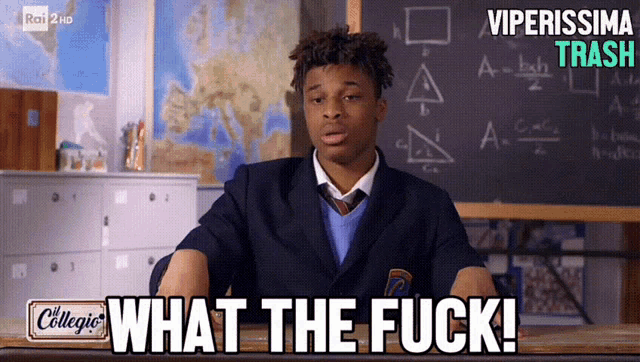 a man sitting at a desk with the words what the fuck in front of him
