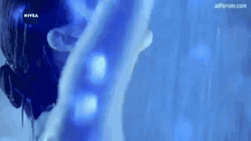 a woman is taking a shower with a nivea logo in the background