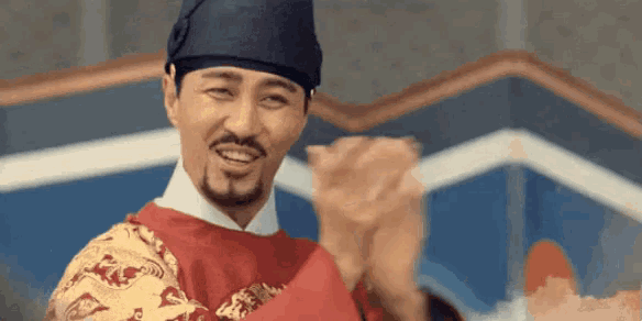 a man with a beard and mustache is wearing a costume and applauding .