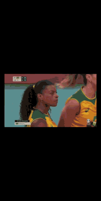 a woman in a yellow and green jersey is standing next to another woman in a green and yellow jersey ..