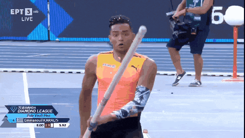 a man is holding a pole in front of a sign that says diamond league