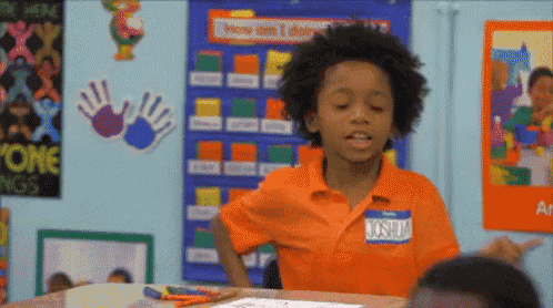 a young boy in an orange shirt has a name tag that says joshua on it