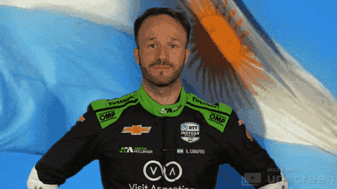 a man with a beard wears a black and green chevrolet racing outfit