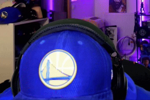 a person wearing headphones and a blue hat with a golden state warriors logo on it