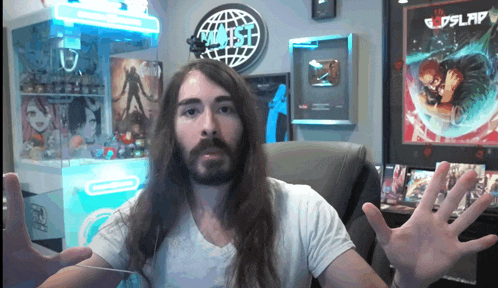 a man with long hair and a beard is sitting in front of a sign that says ' planet ' on it