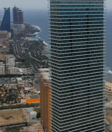 an aerial view of a city with a very tall building in the middle
