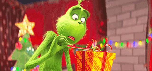 the grinch from the movie the grinch is opening a gift box with a candy cane in it .
