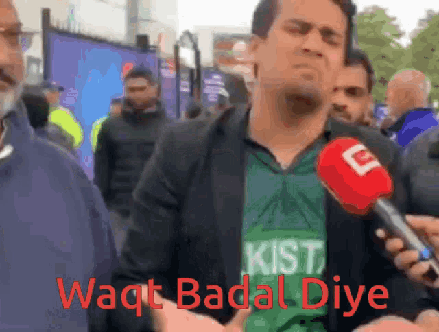 a man wearing a green shirt that says pakistan is being interviewed