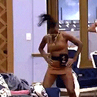 a woman is standing in a room with her hands on her hips and a ponytail .