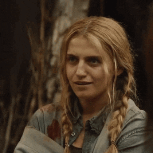 a woman with blonde hair and pigtails is wearing a denim jacket