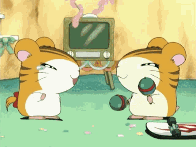 a couple of hamsters standing next to each other with a television in the background