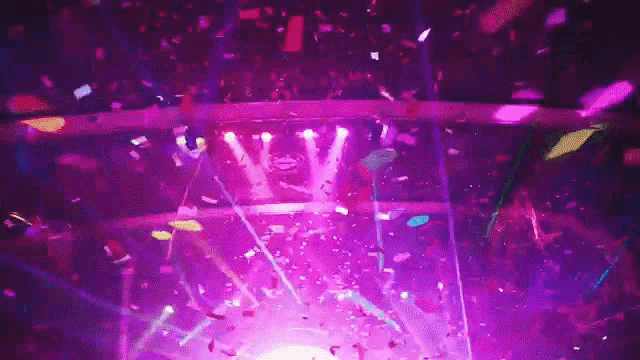 confetti is falling from the ceiling of a stage at a concert