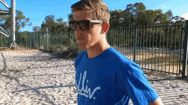 a man wearing sunglasses and a blue t-shirt with the word liv written on it