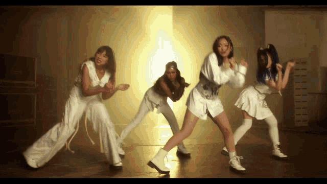 a group of women are dancing in a dark room