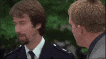 a man in a suit and tie is holding a gun to his mouth .