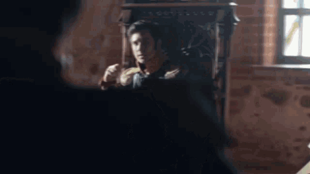 a man is sitting in a chair talking to someone