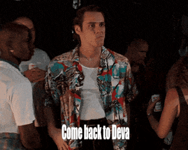 a man in a colorful shirt stands in a crowd with the words come back to deva below him